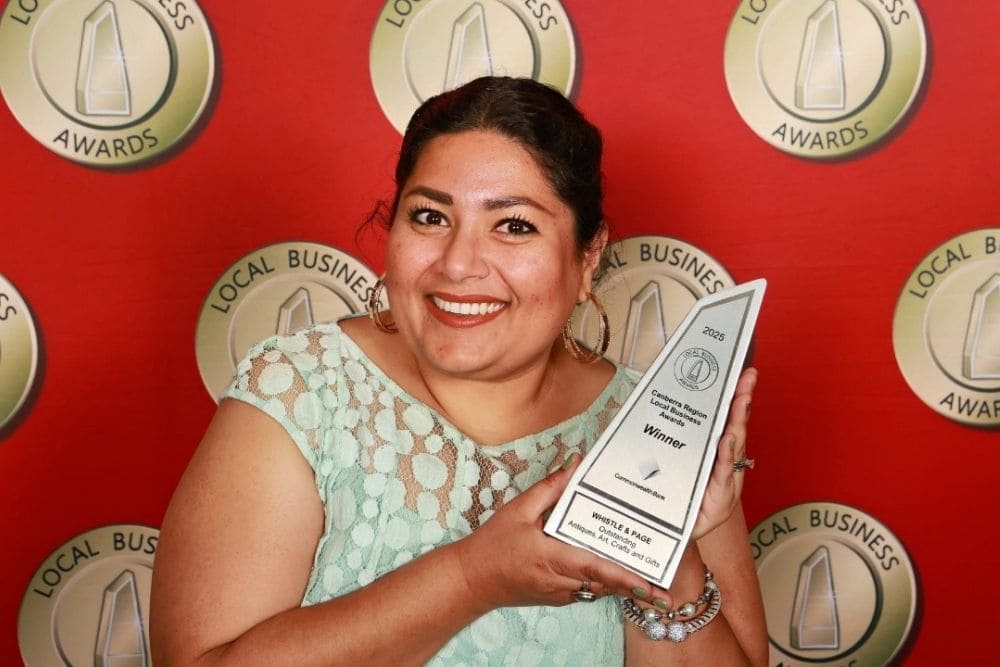 Whistle and Page owner holding a Local Business Award trophy